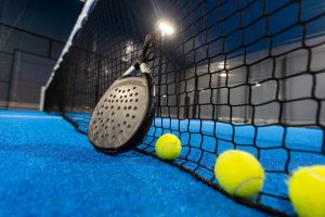 balls near the net of a blue padel tennis court