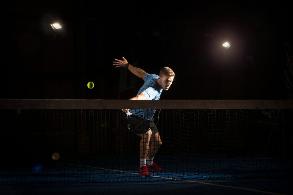 Man playing padel in darkness